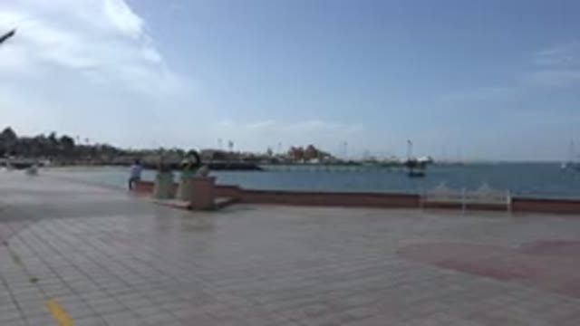 LOS CABOS MEXICO-2017: Blurry View Of Ocean Buildings And Pier From Brick Public Area
