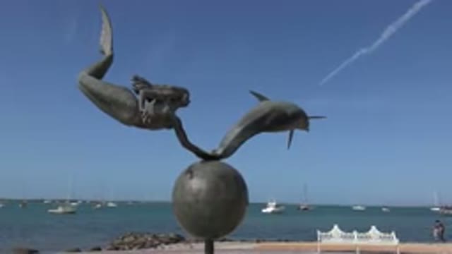 LOS CABOS MEXICO-2017: Seaside Sculpture Of A Mermaid With A Dolphin On Top Of A Globe