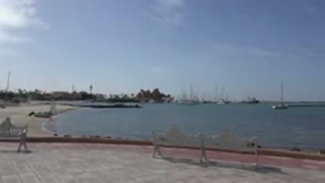 LOS CABOS MEXICO-2017: A Blue Water Sea In The Daylight And Some Few Boats And Trees