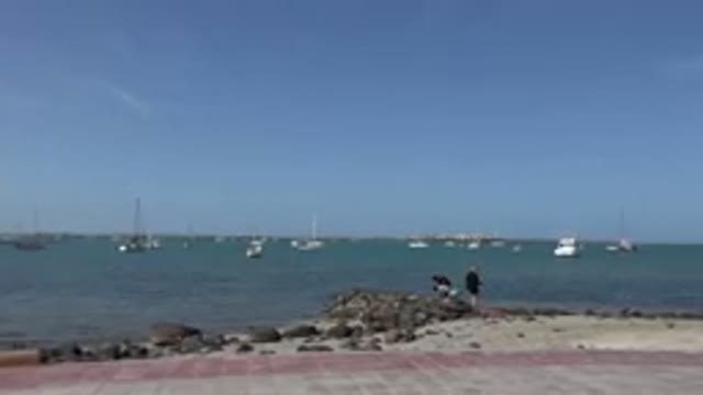 LOS CABOS MEXICO-2017: A View Of A Beach As A Child In A Purple Shirt Walks Up A Ledge