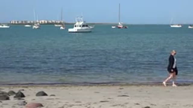 LOS CABOS MEXICO-2017: Woman Walking On Beach With Boats At Sea