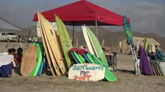 LOS CABOS MEXICO-2017: Couple Relaxing On Beach With Surfboards