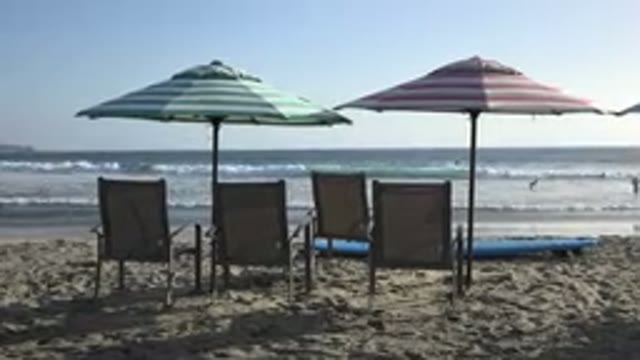 LOS CABOS MEXICO-2017: Beach With Four Wooden Chairs And Two Beach Umbrellas