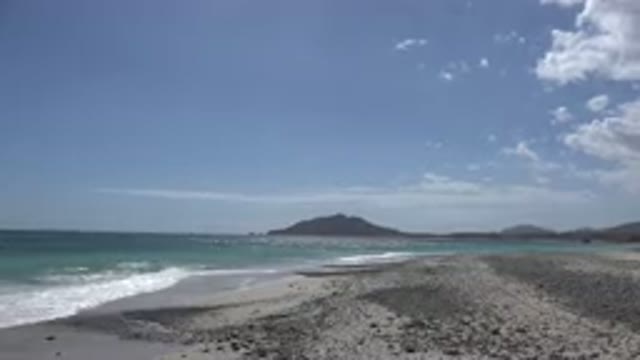 CABO PULMO MEXICO-2017: A Beach With Dark Sand, Light Blue Sky And A Person Alone