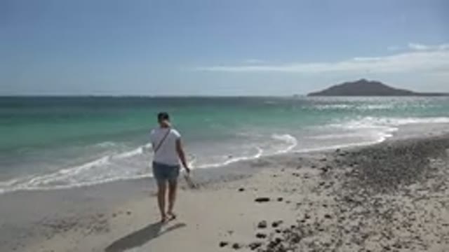 CABO PULMO MEXICO-2017: Barefoot Woman Walking Carefree Alongside Turquoise Ocean