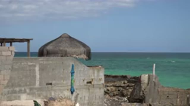 CABO PULMO MEXICO-2017: A Cabana Sits Behind A Cinder Block Wall On A Coast With