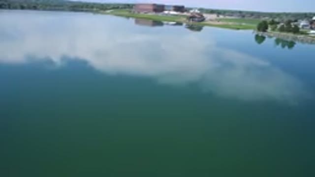 WESTMINSTER COLORADO-2017: Moving Shot of Large Open Body of Water Against Grassy Bank