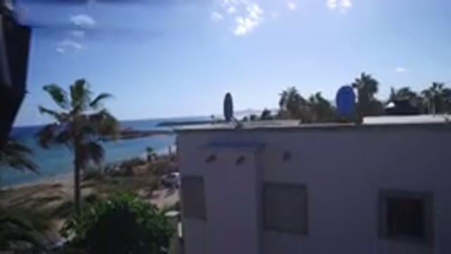 PLAYITA BCS MEXICO-2017: Aerial Drone Rising Shot Side Of Building Next To Palm