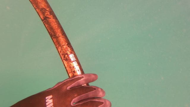 SAN JOSE DEL CABO BCS MEXICO-2023: Gloved Hand Holding Fishing Rod Underwater