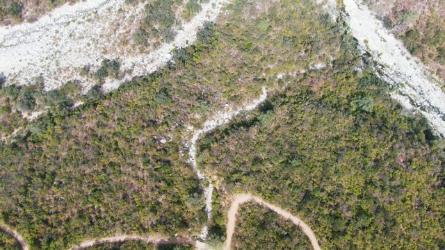 SAN DIONISIO BCS-2023: Vehicle Traveling on Winding Dirt Path Through Hilly Landscape