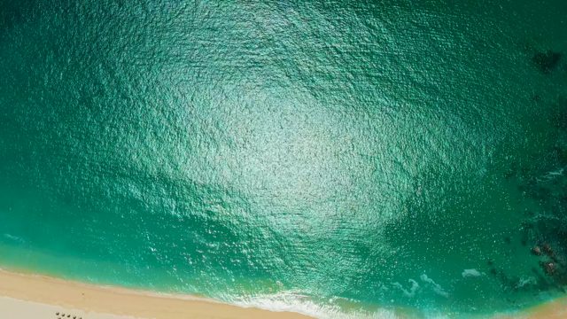 MARQUIS LOS CABOS MEXICO-2021: People Walking Along Turquoise Ocean Shore