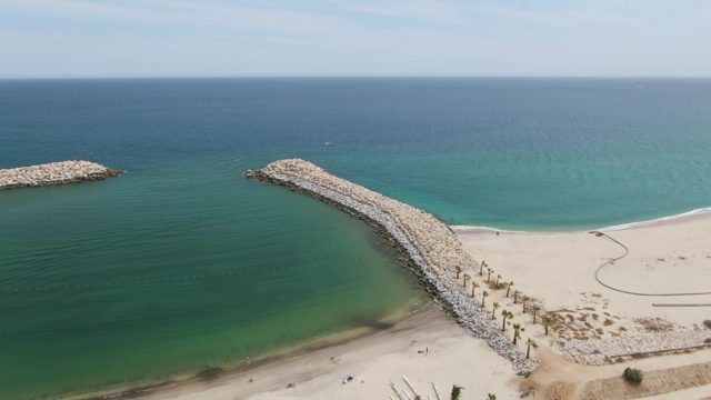 PUERTO LOS CABOS BEACH BCS-2023: Sandy Beach with Rocky Breakwaters and Calm Ocean