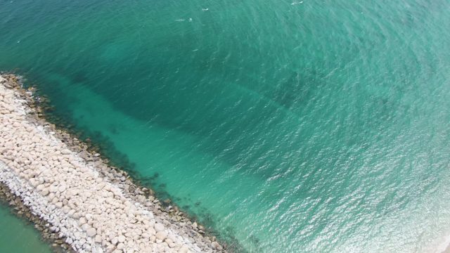 PUERTO LOS CABOS BEACH BCS-2023: Rocky Breakwater in Clear Ocean Near Sandy Beach