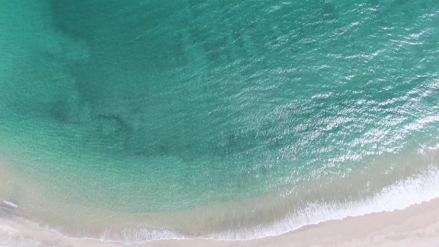 PUERTO LOS CABOS BEACH BCS-2023: Tide Advancing on Sandy Beach with Turquoise Water
