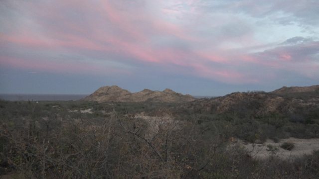 Desert Sunset with Pink and Purple Sky Over Rocky Hills