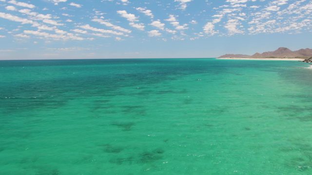 Panning Coastal View of Turquoise Waters and Sandy Shore