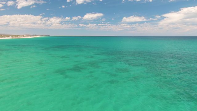 Turquoise Ocean Waters with Distant Sandy Shore