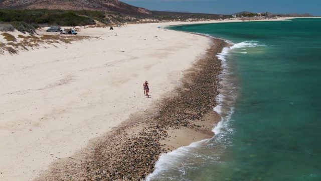 Two People Strolling Along the Beach Shoreline