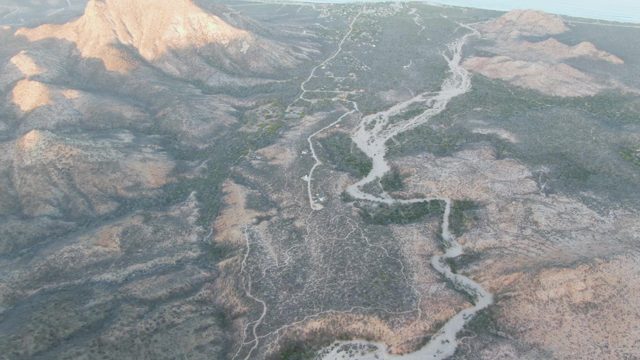 Helicopter Flies Over Mountainous Winding Road