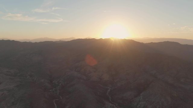 Sun Over Mountainous Valley with Winding River