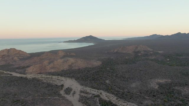 Winding Dirt Road Through Hilly Coastal Landscape at Dusk