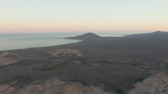 Volcanic Coastline at Dusk with Distant Hill