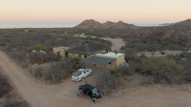 Desert House and Moving Car at Dusk