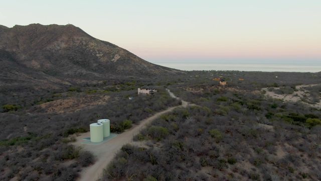 Desert Landscape with Dirt Road and Small Buildings