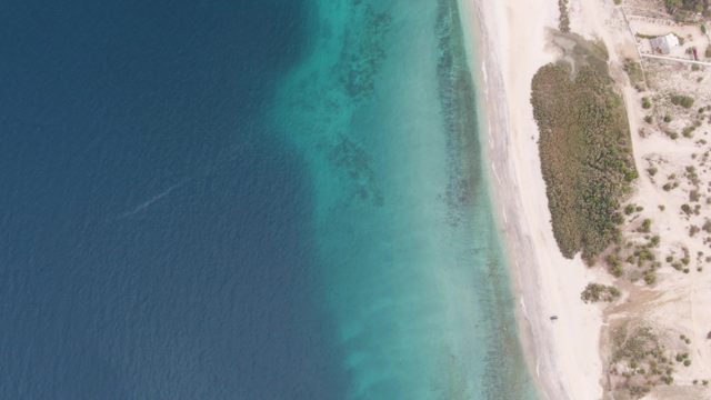 Boat Wake Moving Along Sandy Beach Shore