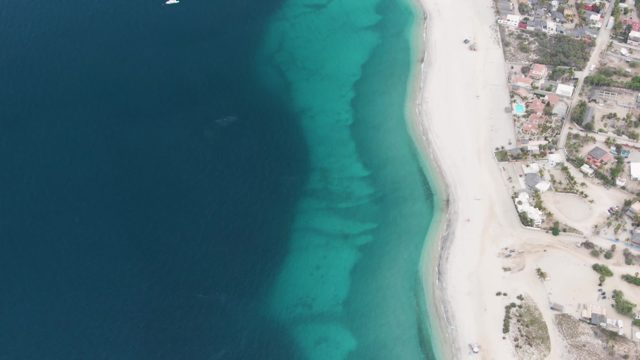 Sandy Beach and Turquoise Ocean with Boat Passing