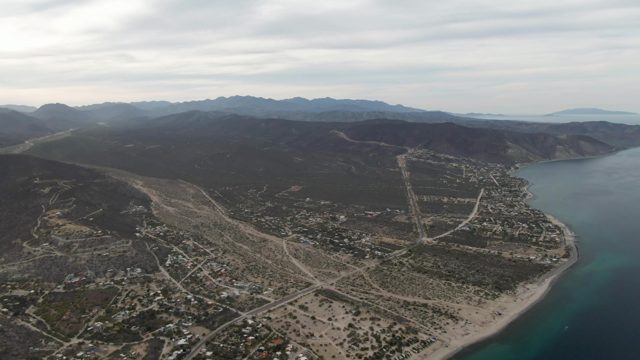 Coastal Town with Mountain Backdrop and Sandy Shore