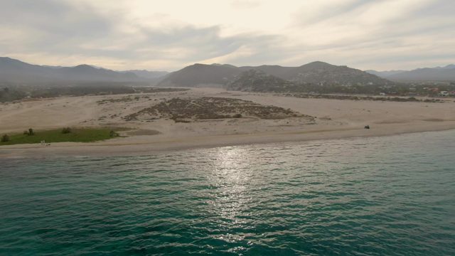Sandy Beach with Dunes and Mountain Backdrop