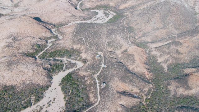 Winding Road Through Arid Hills with Moving Vehicle