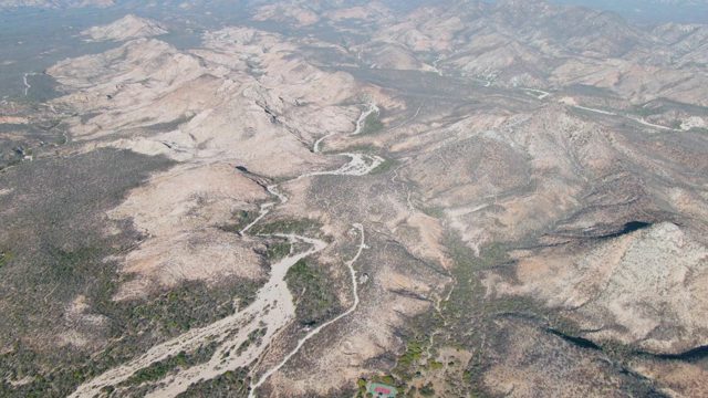 Mountainous Desert Landscape with Winding Road Under Clearing Sky