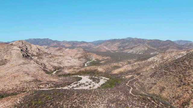 Desert Valley with Winding Dirt Road and Rocky Hills