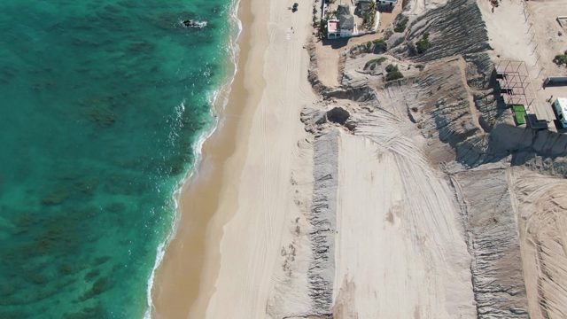 Vehicles Moving on Sandy Beach Path