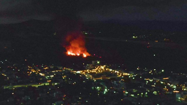 Nighttime Fire on Hill Above Illuminated City