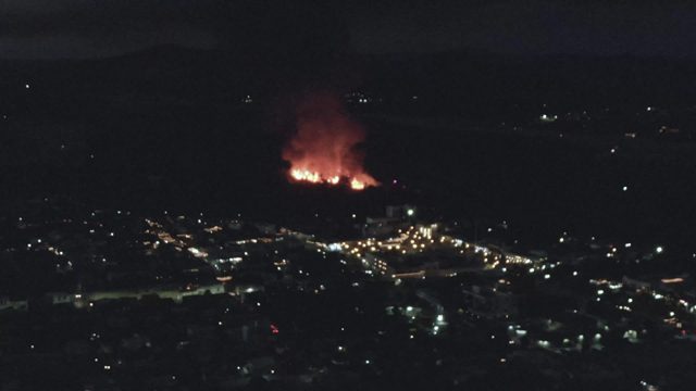 Fire Burning Near City at Night Aerial View