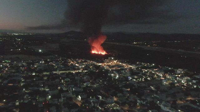 Fire Burning Near City at Night