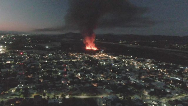 Urban Fire and Rising Black Smoke at Night