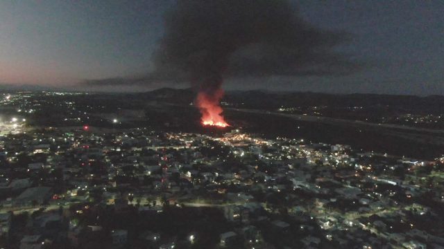 Nighttime City Fire with Rising Black Smoke