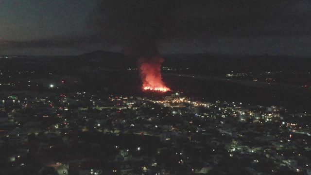 Fire and Smoke Over City at Night