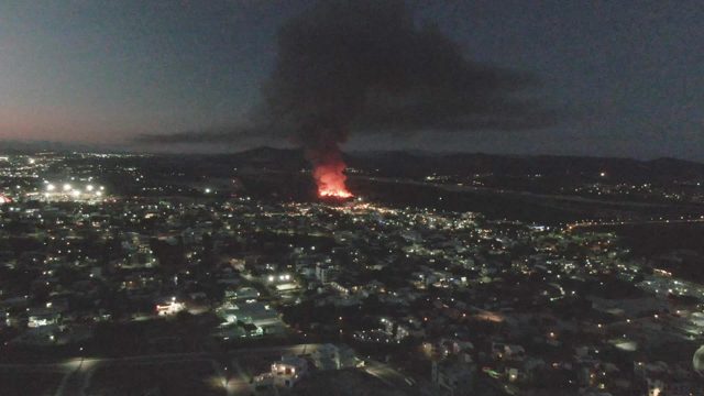 Urban Fire at Night with Rising Black Smoke