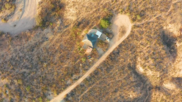 Vehicle Traveling on a Dirt Road in Dry Grassland