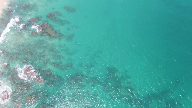Waves Crashing on Rocky Shore From Above