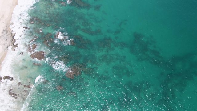 Waves Breaking on Rocky Coastline From Above