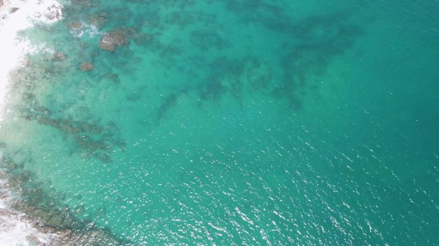 Waves Crashing on Rocky Shore From Above