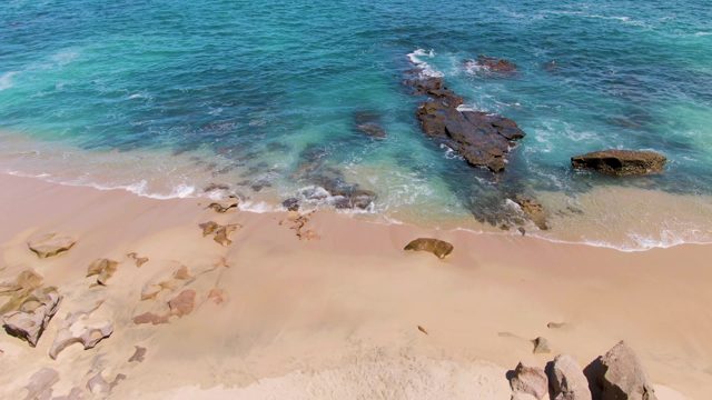 Sandy Beach with Rocky Outcrops and Ocean Waves