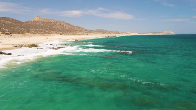 Waves Breaking on Rocky Beach with Clear Turquoise Water