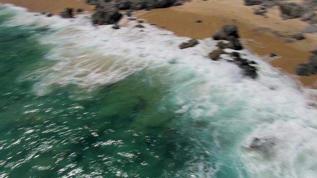 Waves Crashing on Rocky Shore with Turquoise Water